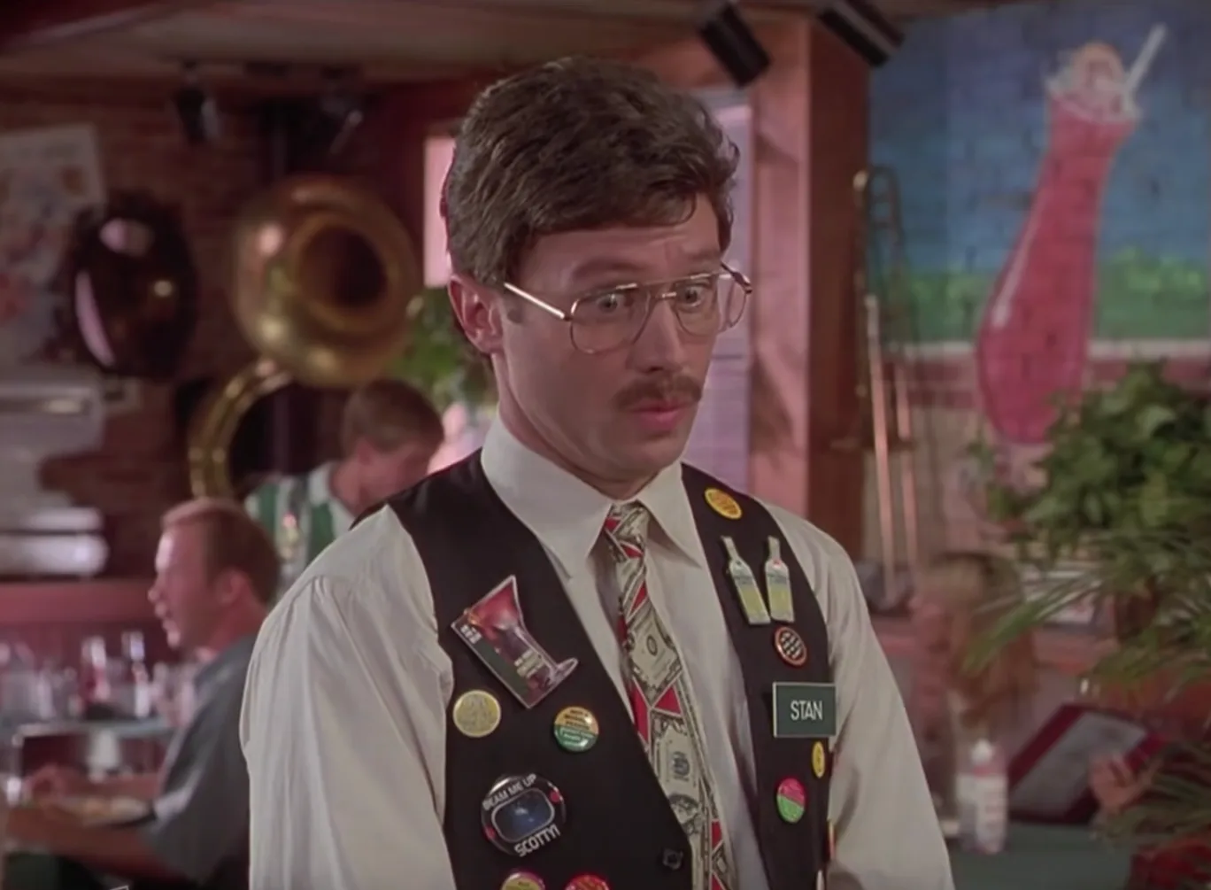 Stan, the Chotchkie's manager in Office Space, wearing a vest covered in buttons